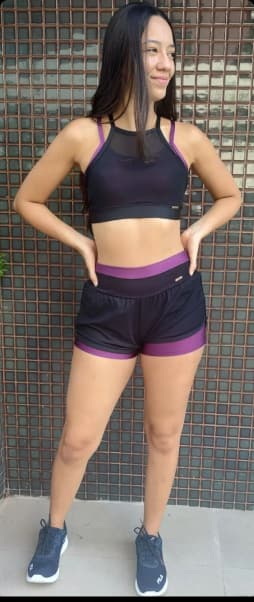 mulher usando roupa de academia com as mãos na cintura